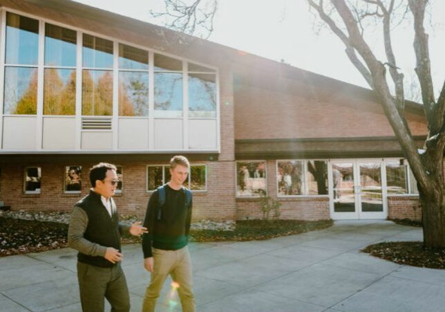 Two individuals walking in front of Calvin Theological Seminary